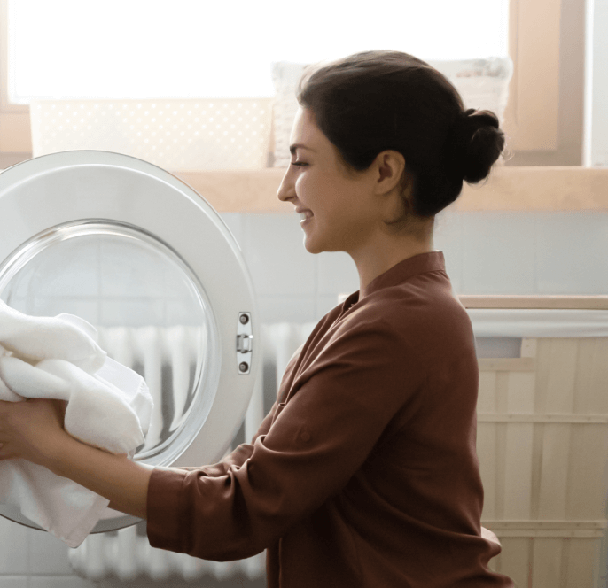 Woman looks inside her fridge.